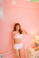 A woman in a white lingerie posing on a bed.