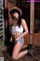 A woman in a cowboy hat is posing for a picture.