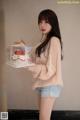A woman holding a box with a cake in it.